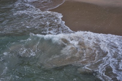 砂浜に船の波が打ち寄せる
